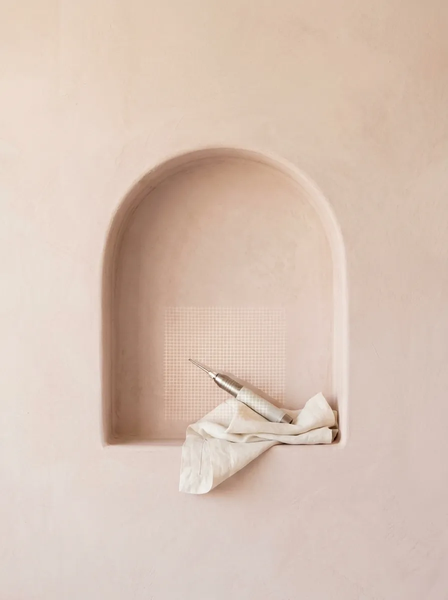A plaster niche holding a fractional CO2 laser handpiece, a fine grid of light on the plaster